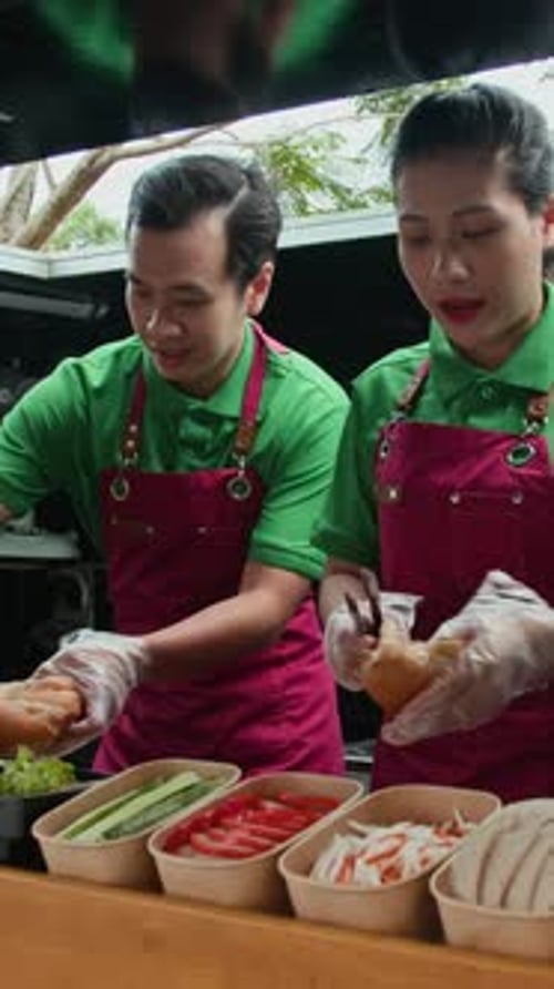 Two People Preparing Tasty Sandwiches