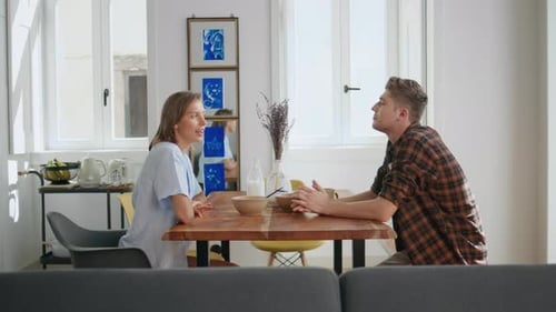 Couple Talking at Table in Brightly Lit Home
