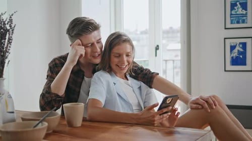 Young Couple Relaxing with Smartphone at Home