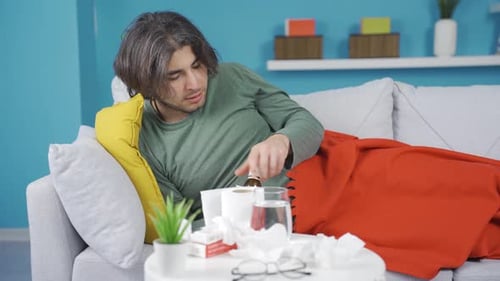 Un homme malade qui éternue, se mouche.