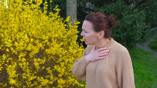 Woman with Asthma Uses Inhaler Outdoors in Spring