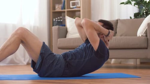 Man Doing Sit-ups on Mat at Home