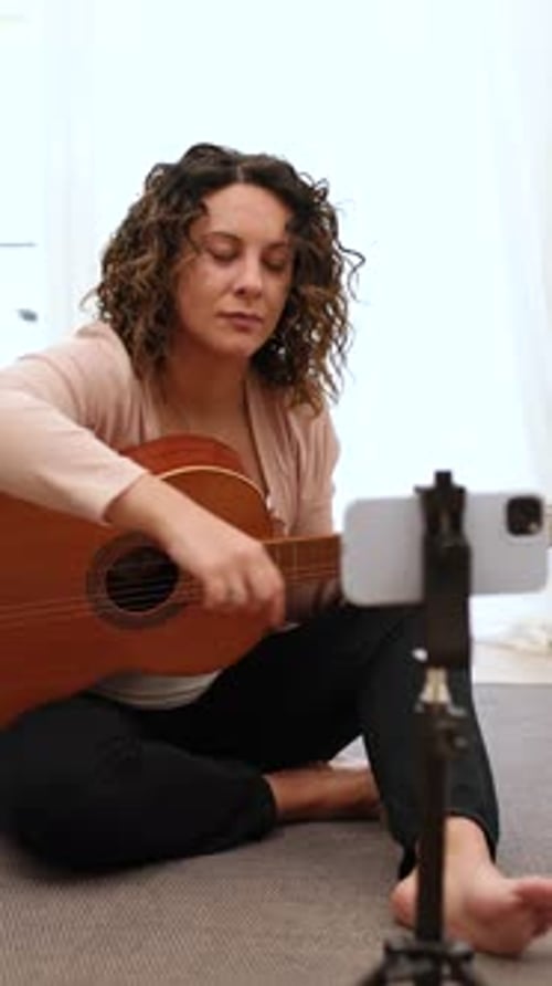 Woman Plays Guitar and Records Video at Home