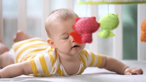 Baby Lying in Crib Looking at Mobile