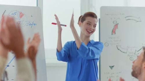 Professional Woman Leading Business Meeting at Whiteboard
