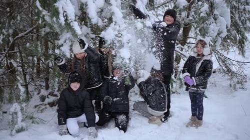 Jugendliche spielen, indem sie sich im Park gegenseitig mit Schnee bewerfen
