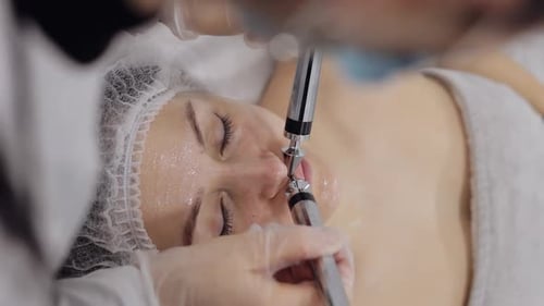 Beautician Doctor Makes Woman Micro Currents Face Therapy Using Electrical Impulses in Spa Salon