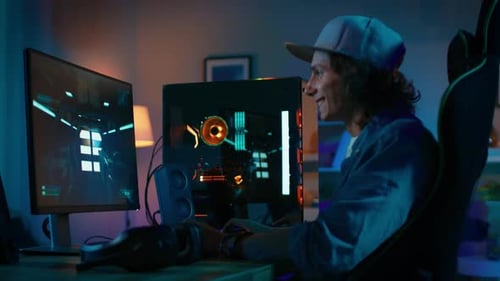 Happy young man plays computer game at home