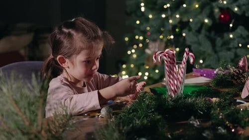 Girl Crafts with Christmas Tree Decorations at Home