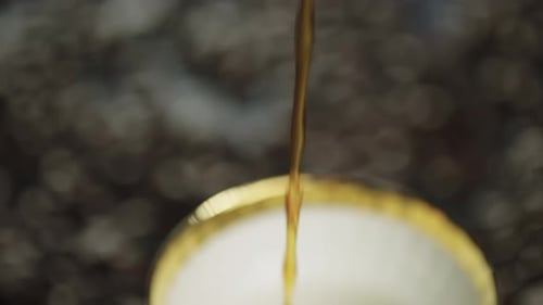 Coffee Pouring into a Teacup in Macro Shot