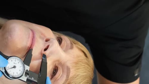 A Doctor is Preparing an Elderly Woman for Plastic Surgery on Her Face Vertical Video