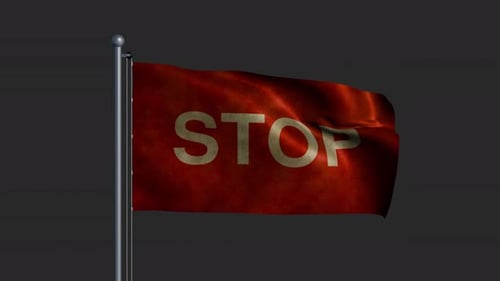 The Word STOP on the Worn Fabric of a Flag Fluttering on a Flagpole