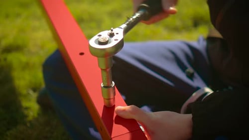 Boulon de serrage mécanique en gros plan avec clé à douille sur une barre d'acier peinte, assemblage, activité de réparation