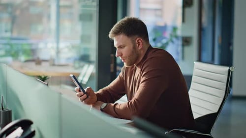 Focused Freelancer Checking Smartphone Intently Sitting Coworking Space Closeup