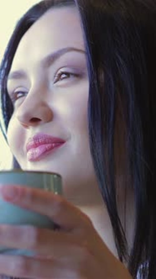 Charming Woman Savoring Coffee at a Cozy Cafe