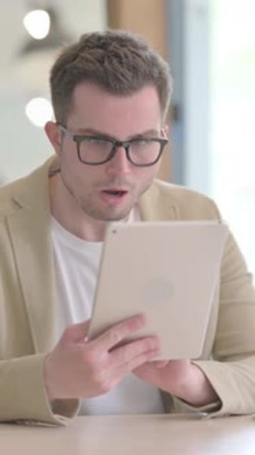 Man With Tablet Looking Surprised in Modern Setting