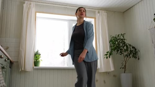 Woman Dancing in Kitchen With White Wood Walls