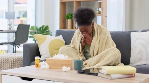 Sick Woman Covered in Blanket Blowing Nose