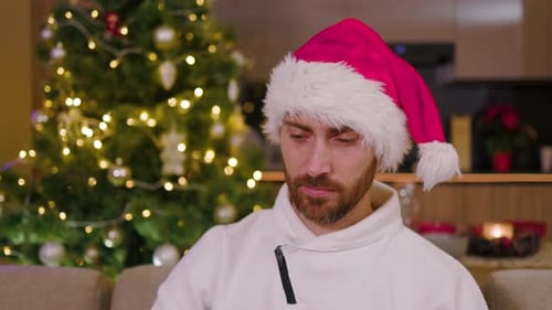 Close Up Portrait of Young Handsome Man with Claus Hat in Winter Sweater Smiling Look at Camera On