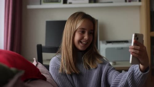Teen Girl Video Chatting and Smiling on Couch