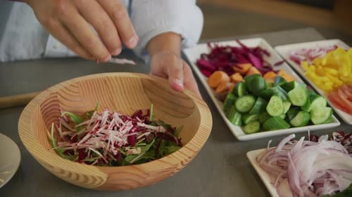 Person Making Salad in Wooden Bowl With Vegetables