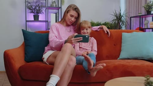 Mother and Child Enjoying Phone on Couch