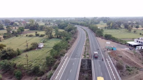 Drone aerial view of a generic looking well maintained national highway of India with rural landscap