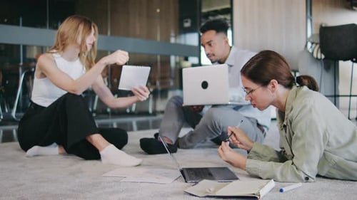 Séance de travail collaborative dans un espace de bureau moderne mettant en vedette trois jeunes professionnels dynamiques