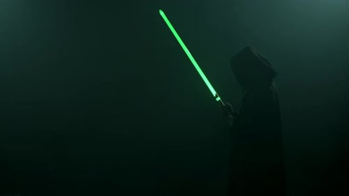 Junger Mann im Cosplay-Kostüm mit Lichtschwertkampf auf schwarzem Hintergrund in Smoke and Rain Slow