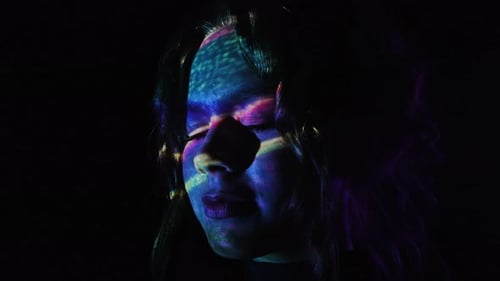 Colorful Light Reflections on a Woman Face in Dark Background