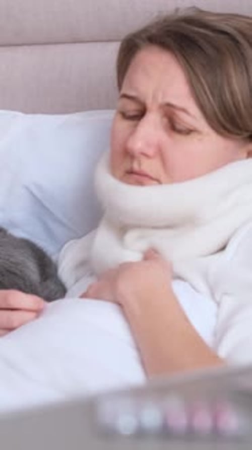 Portrait d'une jeune femme malade allongée sur le lit et toussant Vidéo verticale