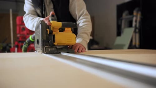 Close Up Footage of Carpenter Using Electric Circular Saw to Cut Wood During Construction or