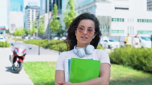 Young Woman with Notebooks in an Urban Setting