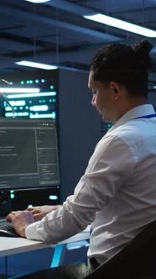 Vertical Video Portrait of Cheerful Engineer in Data Center Installing Software on Computer