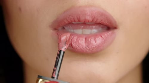 Close Up of Female Lips Hand of Woman Putting Liquid Lipstick Natural Color