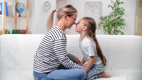 Loving Mother and Child Touch Noses on Couch