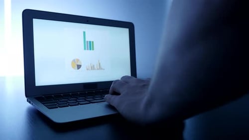 Hand Types on Laptop Displaying Graphs