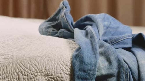 Clothes Being Piled on a Bed