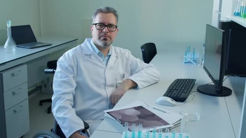 Scientist in Wheelchair at Desk in Laboratory