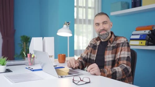 Man Working at Desk Giving Thumbs Up