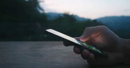 Using Smartphone at Dusk in the Mountains