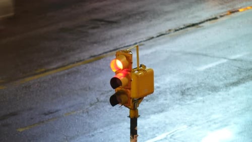 Vista aproximada de um semáforo que muda de luz verde para amarela e vermelha. Luzes de velocidade borradas dos carros pa