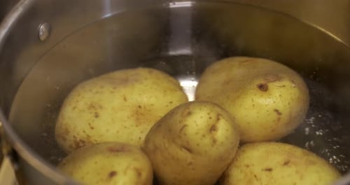 Close up of boiling skinned potatoes in a cooking pot