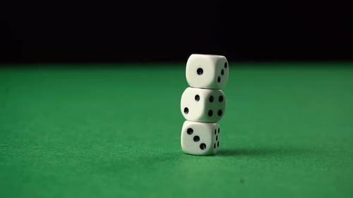 Throwing dice on a game table knocking other dices over.