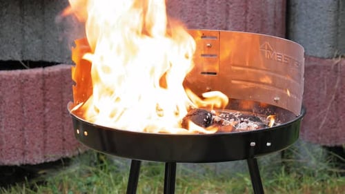 Spraying Gas To Add Fire On Charcoal In A Barbecue Grill Outdoor. close up