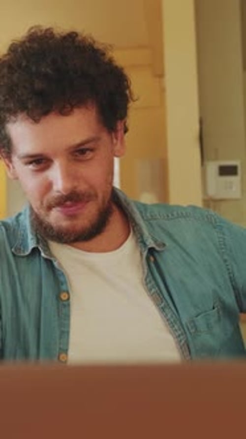 Young Adult Man Working on Laptop at Home