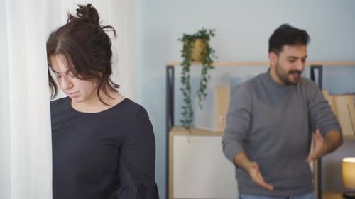 Upset Woman Covering Face, Man in Background