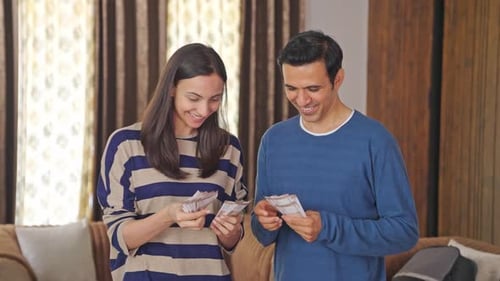 Happy Indian couple counting money