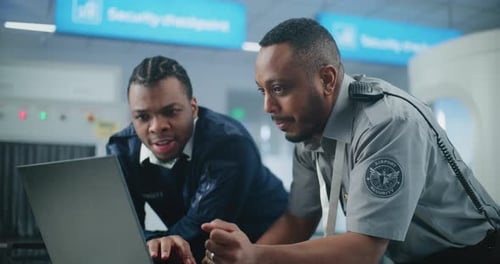 Airport Security Checkpoint TSA Workers Using Laptop Discussing Security Issues