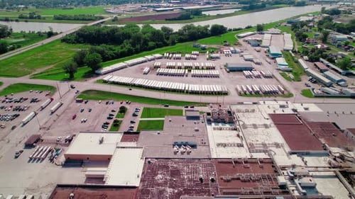 Aerial view showing semi trucks on the road and a large parking lot filled with trailers, alongside